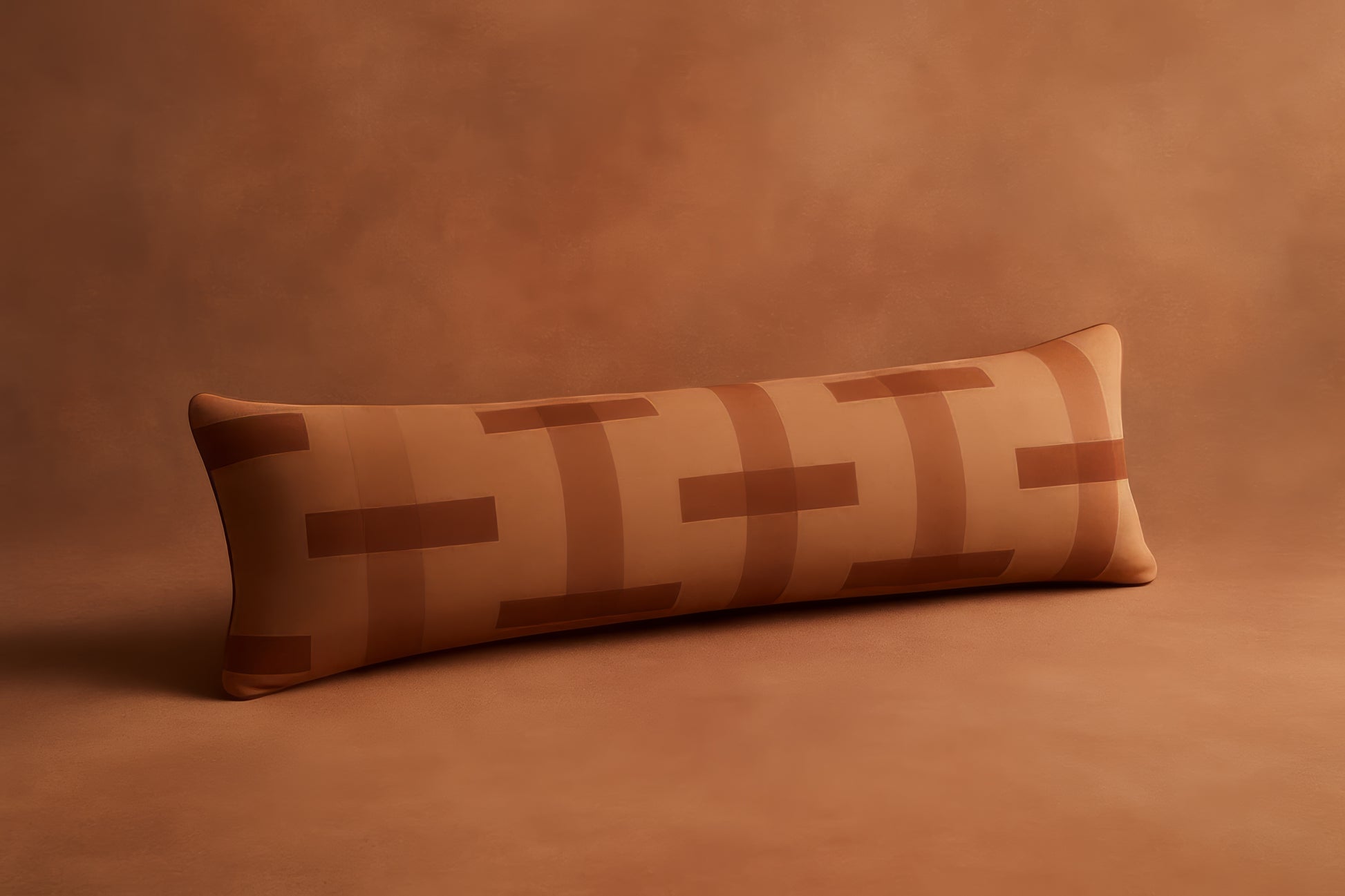 Long rectangular pillow with a geometric pattern on a brown background