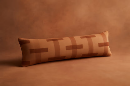 Long rectangular pillow with a geometric pattern on a brown background